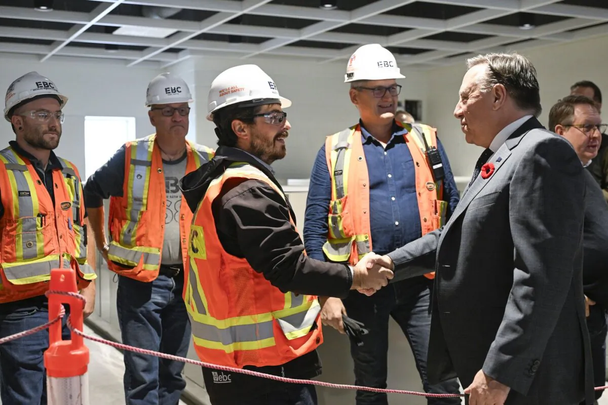Quebec Premier François Legault meets construction workers inside a school under construction during an announcement in Quebec City, on Oct. 30, 2023. (The Canadian Press/Jacques Boissinot)