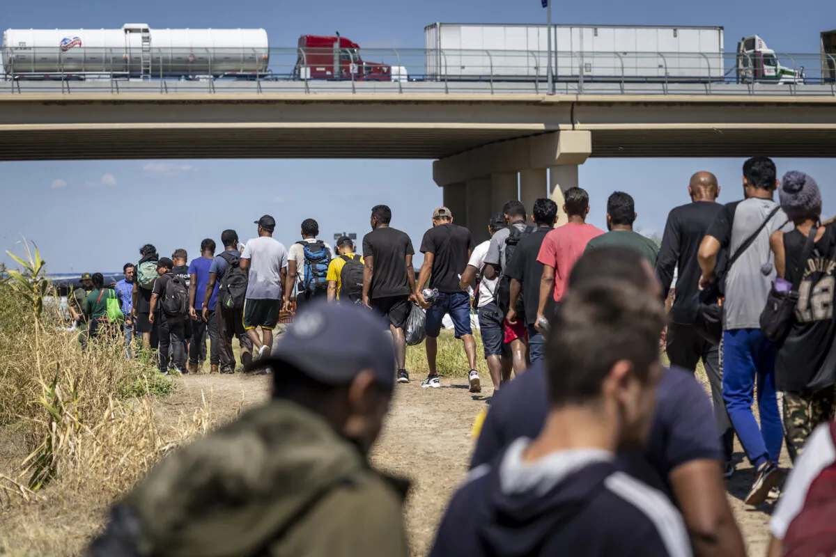 Illegal immigrants walk toward a U.S. Border Patrol checkpoint after crossing the U.S.-Mexico border in Eagle Pass, Texas, on Sept. 28, 2023. (John Moore/Getty Images)