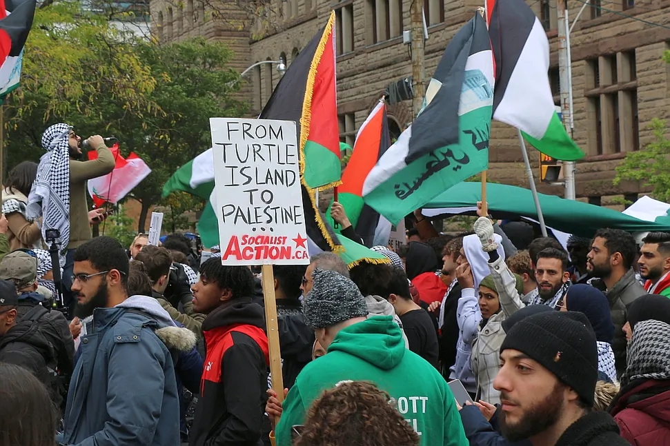 A protester holds a sign that reads "From Turtle Island to Palestine" at a rally in downtown Toronto on Oct. 9, 2023. (Andrew Chen/The Epoch Times)