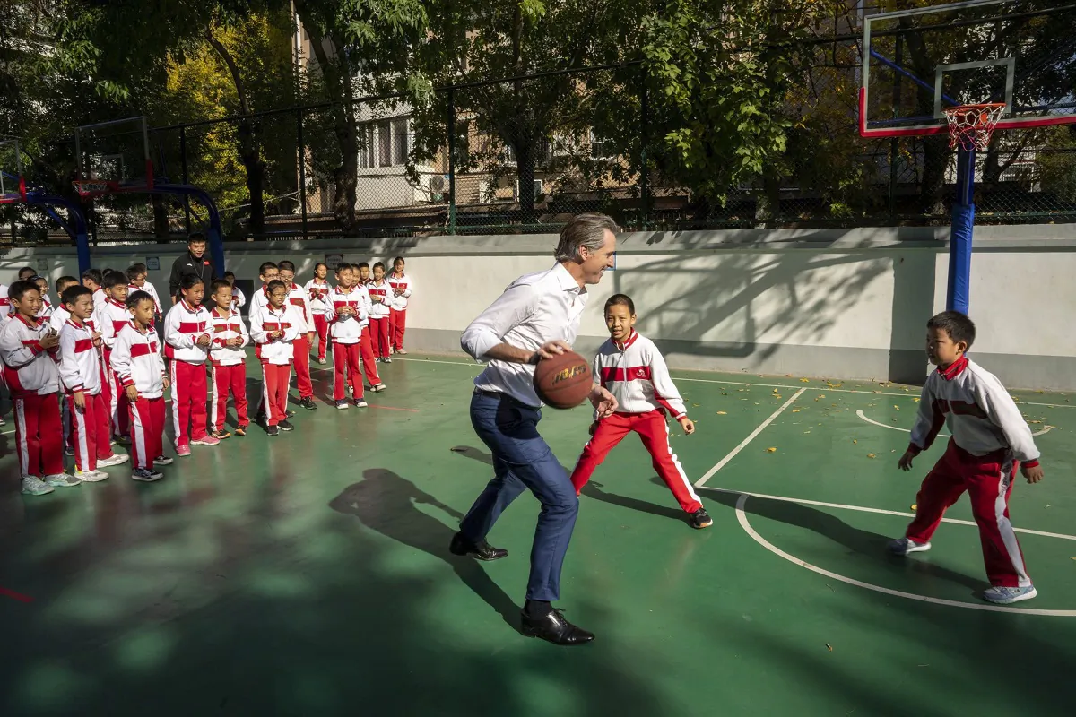 Gov. Gavin Newsom plays basketball with children at a school in Beijing on Oct. 27, 2023. (Courtesy of Office of the Governor of California via AP)