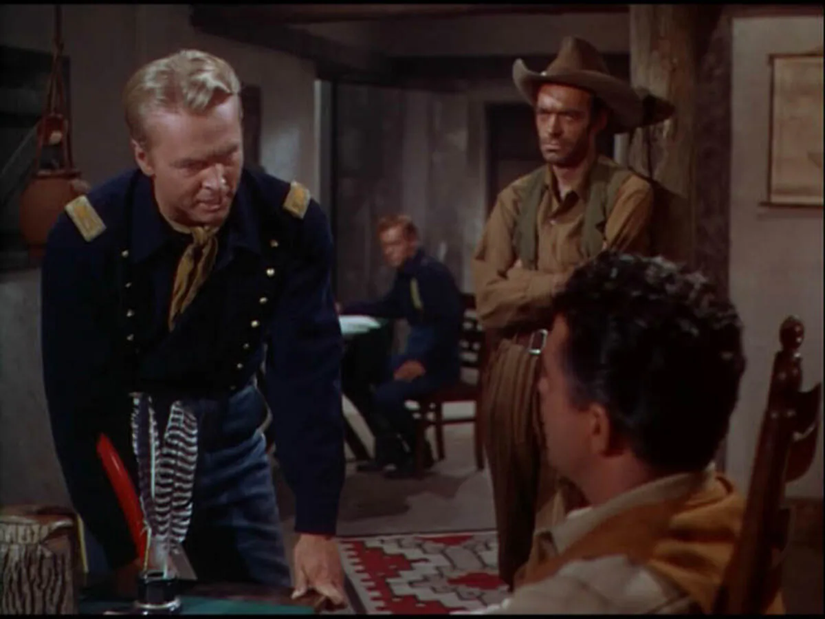 Maj. Jim Colton (John Lund, L) trades verbal barbs with Neil Baylor (Bruce Cowling, R), while Mescal Jack (Jack Elam) looks on, in “The Battle at Apache Pass.” (Universal–International)