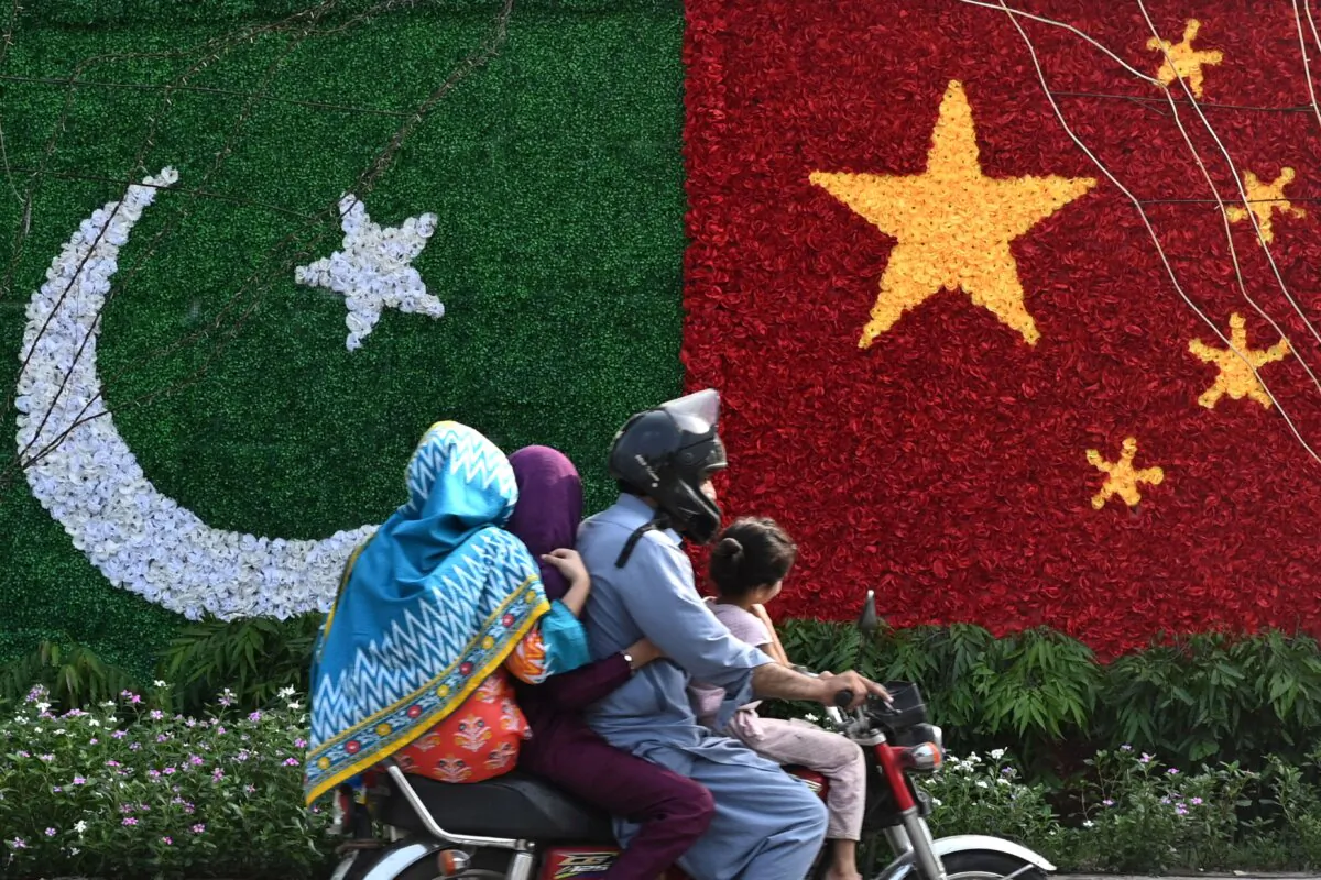 A family rides past a decoration in the shape of the national flags of China and Pakistan installed along a road ahead of the visit of Chinese Vice Premier He Lifeng, in Lahore on July 30, 2023. (Arif Ali/AFP via Getty Images)