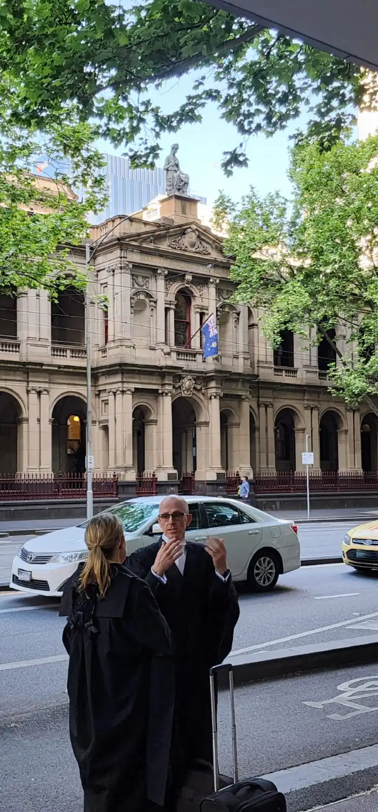Two legal professionals discuss a case outside the Supreme Court of Victoria in Melbourne, Australia, on Oct. 27, 2023. (Susan Mortimer/The Epoch Times)