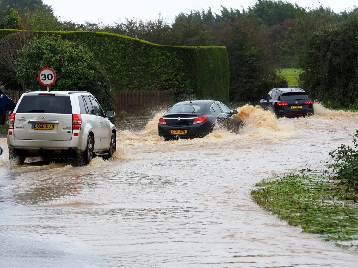 Vehicles are driven through a flooded road in Yapton, West Sussex on Nov. 2, 2023. (Joe Sene/PA Wire)