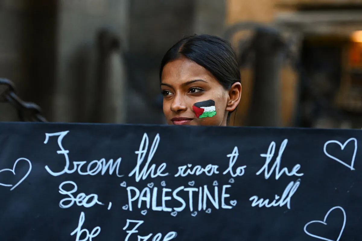 A demonstrator holds a placard reading "From the river to the Sea, Palestine will be free" during a rally in support of Palestinians in Milan, Italy, on Oct. 10, 2023. (Piero Cruciatti/AFP/Getty Images/Tribune Content Agency)