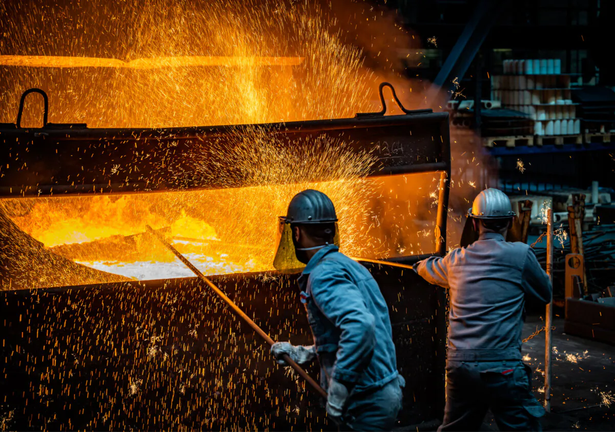 Workers prepare to pour ductile iron casting molten iron into a mould at the Siempelkamp Giesserei foundry in Krefeld, Germany, on April 21, 2022. (Sascha Schuermann/Getty Images)