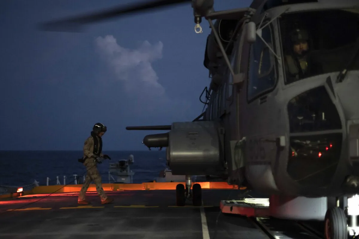 Corporal Riley Aucoin, an Aviation Systems Technician, approaches HMCS Ottawa’s embarked CH-148 Cyclone helicopter “GREYWOLF” upon completion of flight operations in the South China Sea during Indo-Pacific Deployment on Oct. 7, 2023. (Aviator Gregory Cole, Canadian Armed Forces Photo)