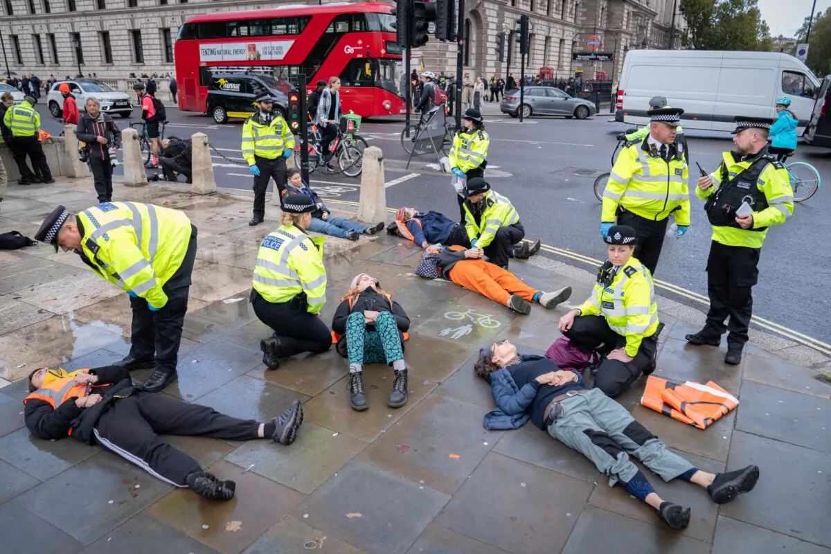 Just Stop Oil activists are detained by police officers during a demonstration in Parliament Square, Westminster, central London, on Oct. 30, 2023. (Stefan Rousseau/PA)