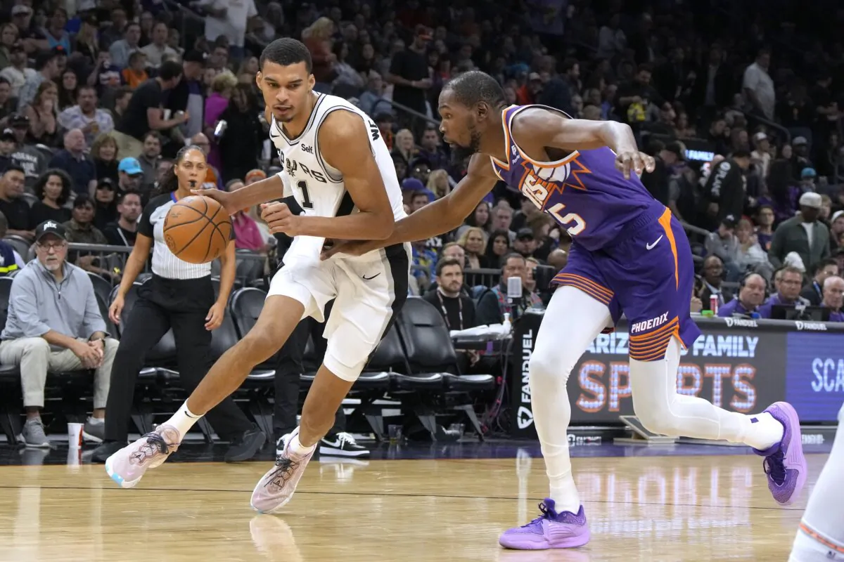 San Antonio Spurs center Victor Wembanyama (1) drives on Phoenix Suns forward Kevin Durant during the second half of an NBA basketball game in Phoenix on Nov. 2, 2023. (Rick Scuteri/AP Photo)