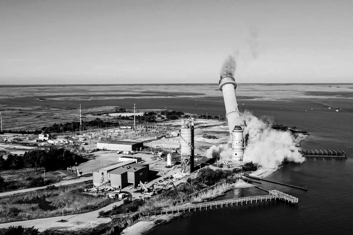 The smokestack at the former B.L. England coal- and oil-burning power plant in Upper Township, N.J., is toppled during a demolition on Oct. 26, 2023. (AP Photo/Ted Shaffrey)