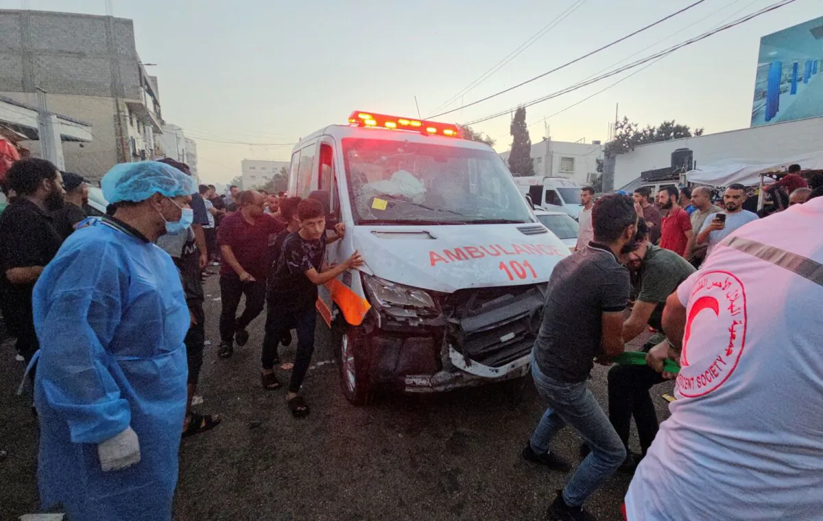 Palestinians pull an ambulance after a convoy of ambulances was hit, at the entrance of Shifa hospital in Gaza City, on Nov. 3, 2023. (Anas al-Shareef/Reuters)