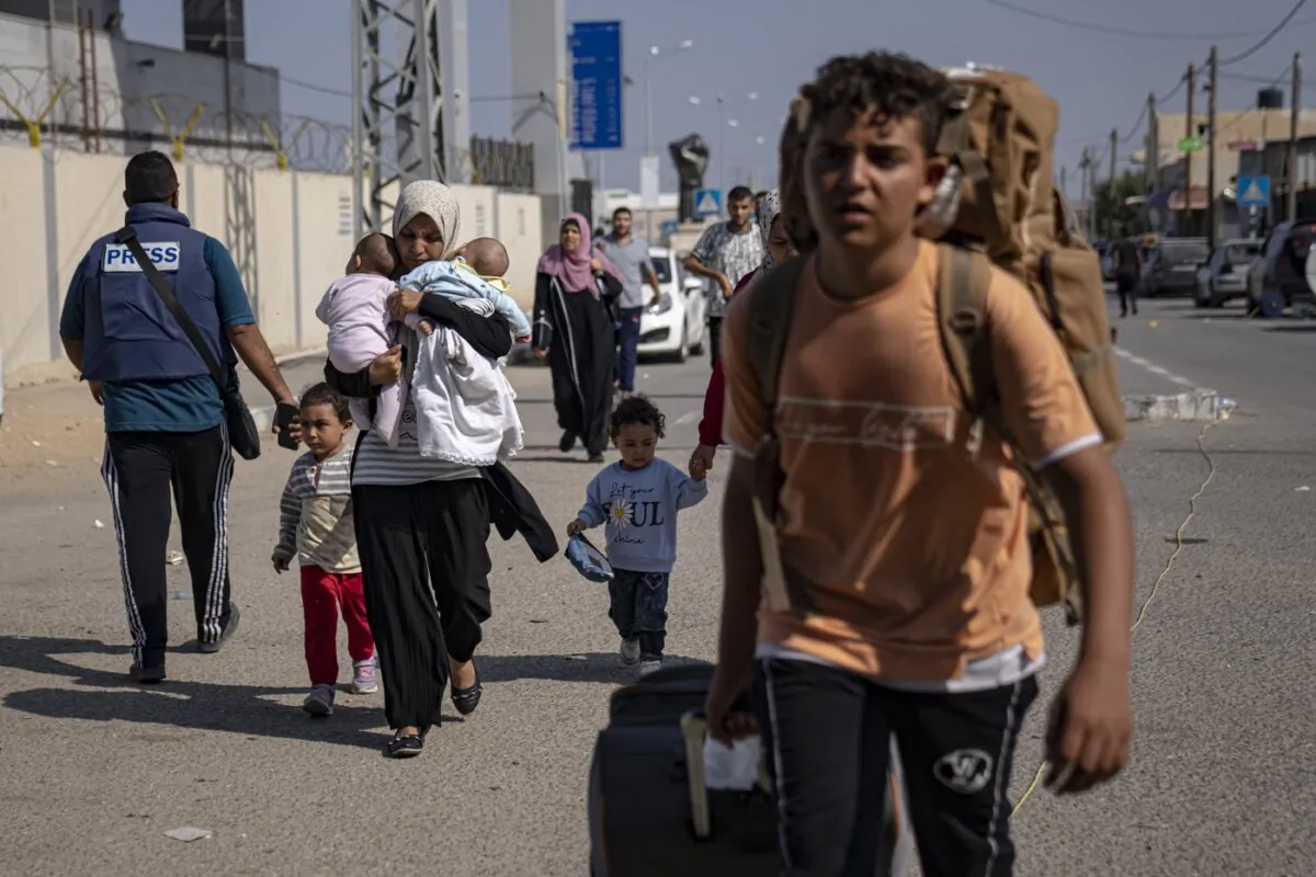 Palestinians arrive at Rafah, the border crossing between the Gaza Strip and Egypt, on Nov. 1, 2023. (The Canadian Press/AP, Fatima Shbair)