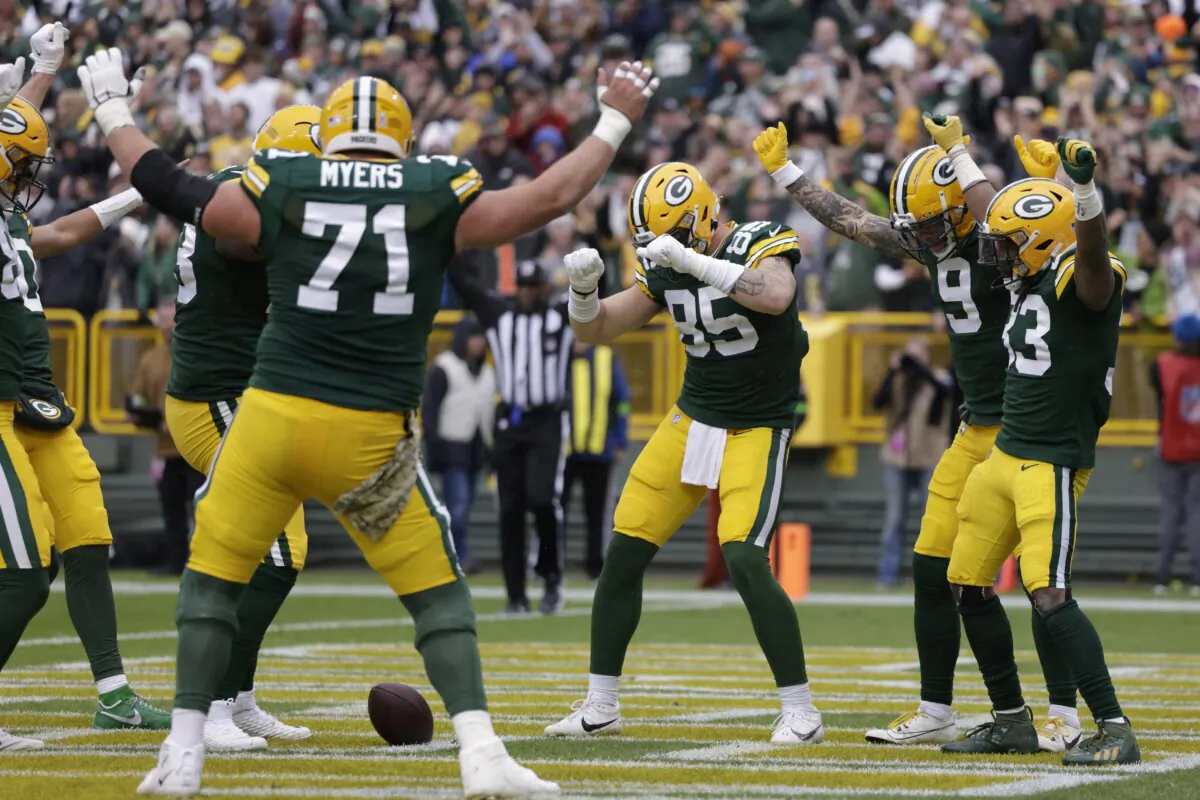 Green Bay Packers running back Aaron Jones (33), right, celebrates with teammates after scoring a 3-yard rushing touchdown during the first half of an NFL football game against the Los Angeles Rams in Green Bay, Wis., on Nov. 5, 2023. (Matt Ludtke/AP Photo)