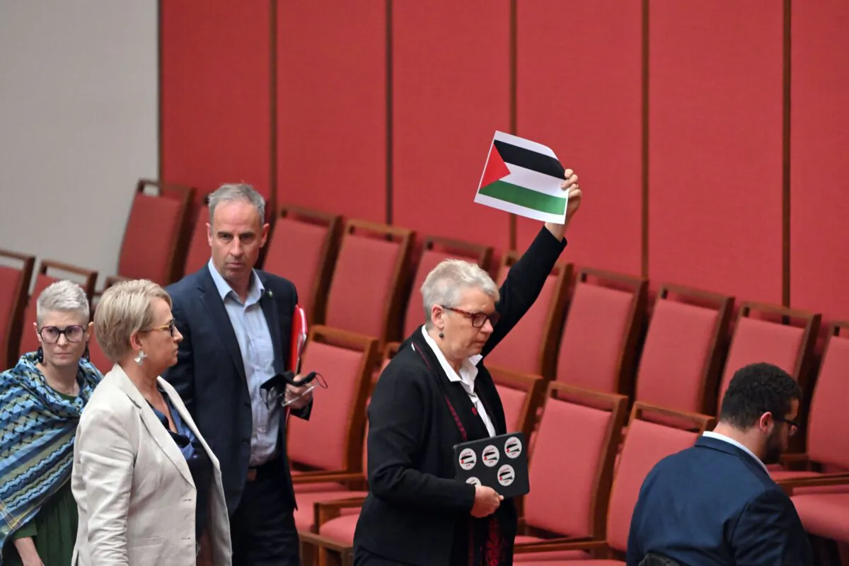 Greens Senator Janet Rice holds a Palestinian flag during a walk out by the Greens during Question Time in the Senate chamber at Parliament House in Canberra, Australia, on Nov. 6, 2023. (AAP Image/Mick Tsikas)