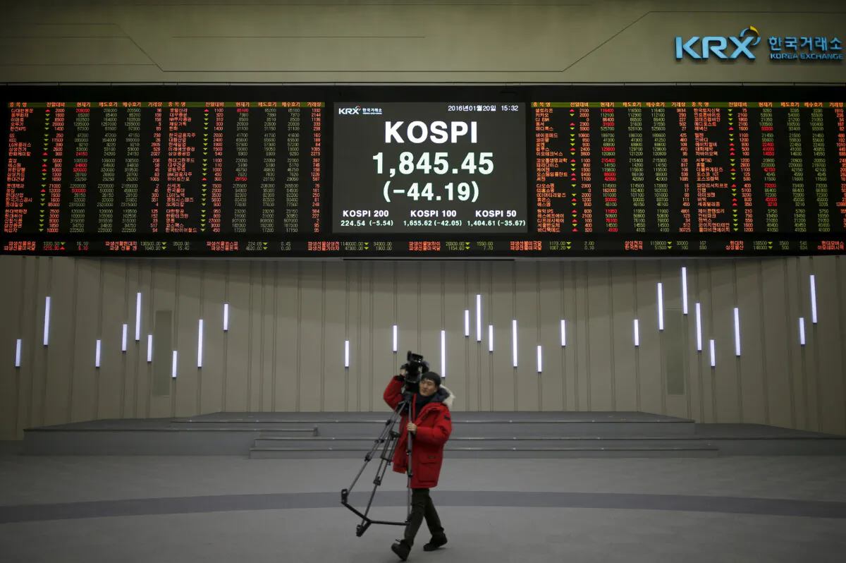 A journalist walks past an electronic board of the Korea Composite Stock Price Index (KOSPI) at the Korea Exchange (KRX) in Seoul, South Korea, Jan. 20, 2016  (Reuters/Kim Hong-Ji/File Photo)