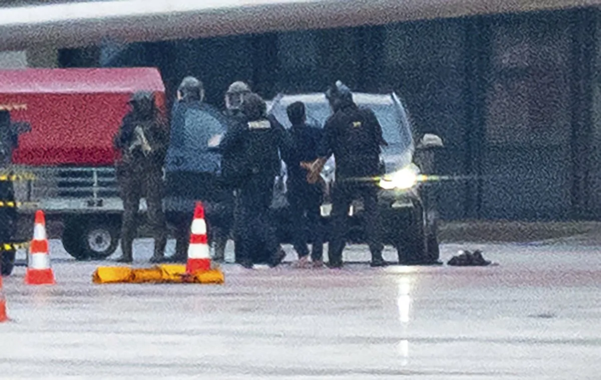A man is led away by the police at the airport in Hamburg, Germany, on Nov. 5, 2023. The hostage situation at Hamburg Airport has ended around 18 hours after a man drove his vehicle through the gates of the airport with his 4-year-old daughter inside. (Jonas Walzberg/dpa via AP)
