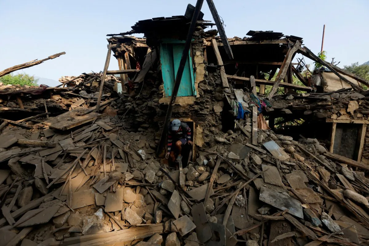 A man walks out from the door of his house as he salvages goods from his collapsed house after an earthquake in Jajarkot, Nepal, on Nov. 6, 2023. (Navesh Chitrakar/Reuters)