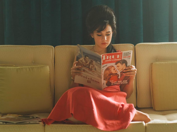 girl in red skirty on couch in PRISCILLA