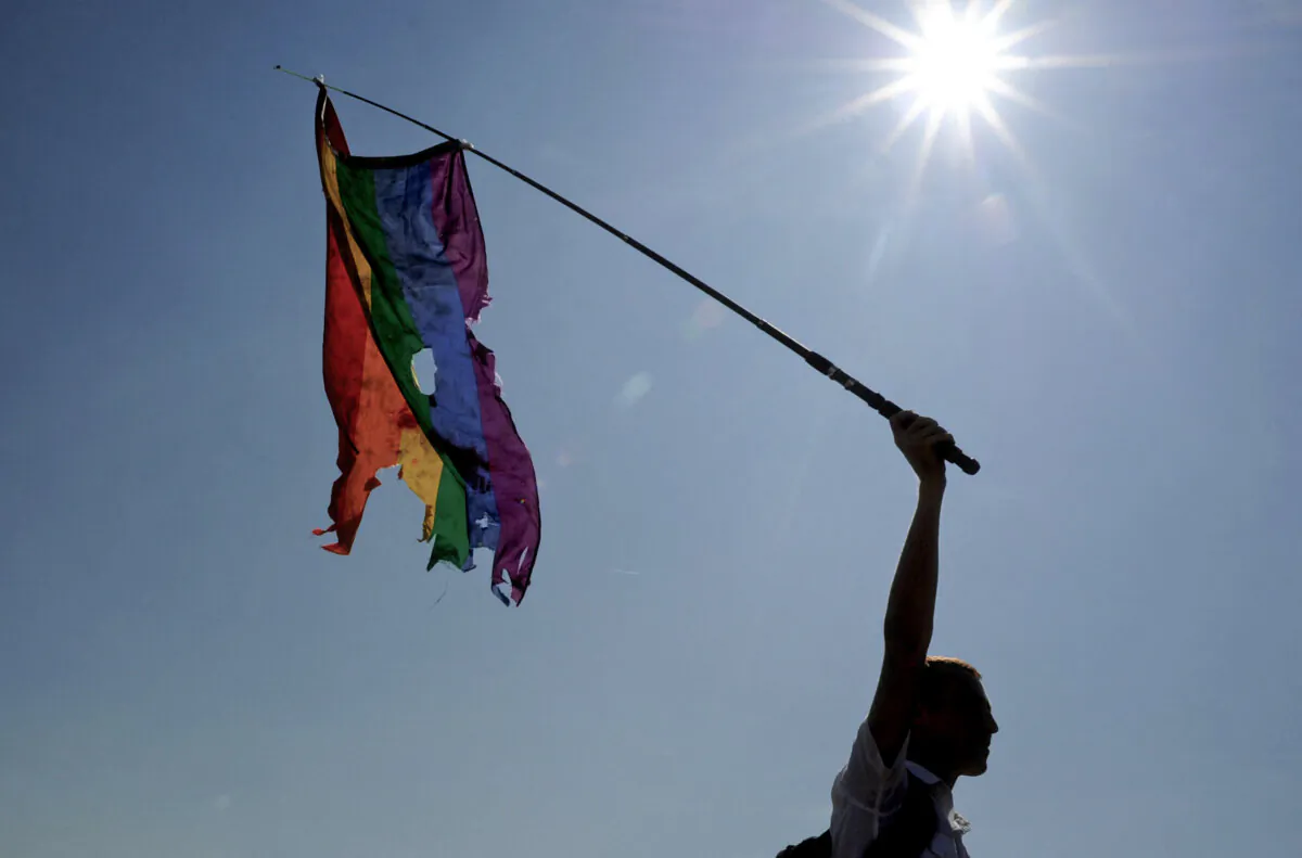 An activist waves a damaged rainbow flag during a gay pride event in St. Petersburg on July 26, 2014. (Olga Maltseva/AFP via Getty Images)