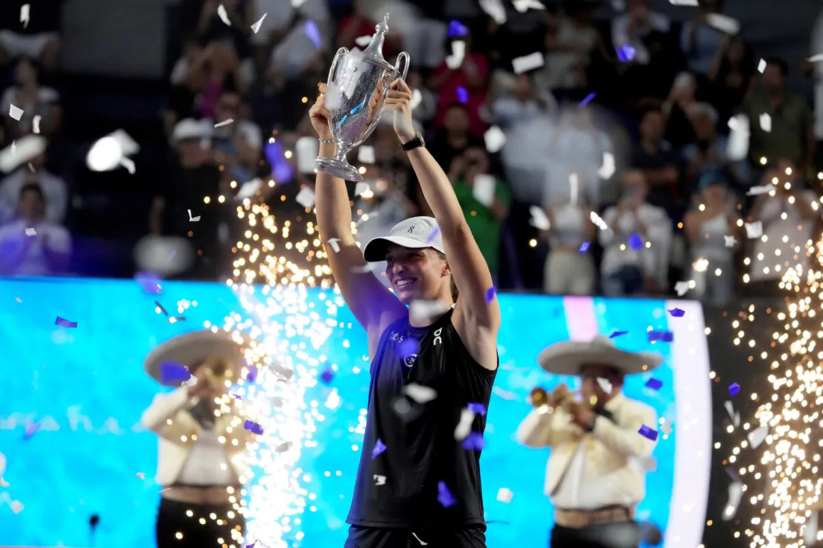 Iga Swiatek, of Poland, holds up her trophy after her victory over Jessica Pegula, of the United States, in the women's singles final of the WTA Finals tennis championships, in Cancun, Mexico, on Nov. 6, 2023. (Fernando Llano/AP Photo)