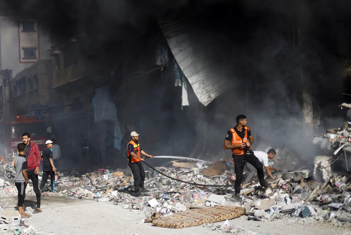 Palestinian firefighters work to put out a fire at the site of Israeli strikes on a residential building, in Khan Younis in the southern Gaza Strip, on Nov. 7, 2023. (Mohammed Salem/Reuters)