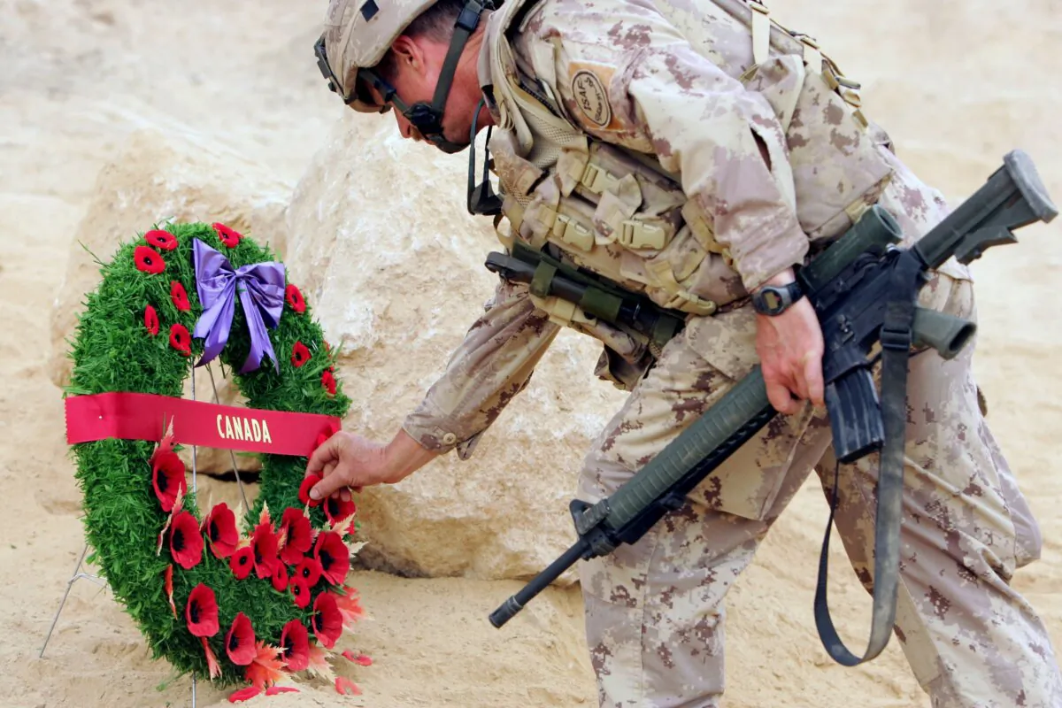 A Canadian soldier lays a wreath during a Remembrance Day ceremony at Forward Operating Base Masum Gar in Panjwayi district, Kandahar province, Afghanistan, on Nov. 11, 2006. (John D. McHugh/AFP via Getty Images)