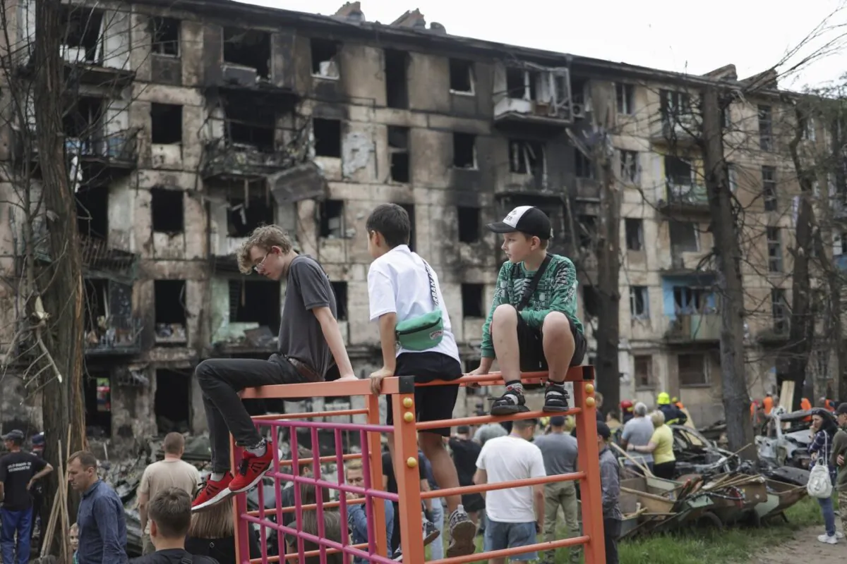 Children look at the scene of the latest Russian rocket attack that damaged a multi-storey apartment building in Kryvyi Rih, Ukraine, on June 13, 2023. (The Canadian Press/AP/Andriy Dubchak)
