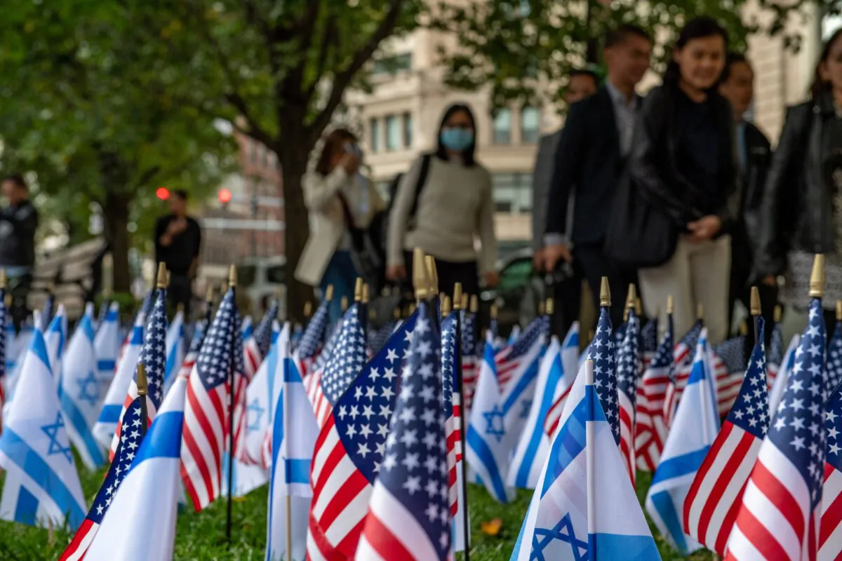 People walk by US and Israeli flags at Statler Park in Boston, Massachusetts, on October 18, 2023.  (Joseph Prezioso/AFP via Getty Images)