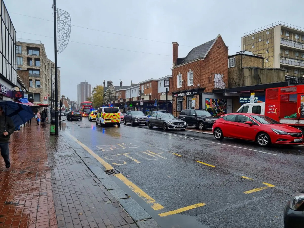 A police car and van drive down Tottenham High Road - heart of London's Turkish and Kurdish community - in Tottenham, north London, on Nov. 8, 2023. (Chris Summers/The Epoch Times)