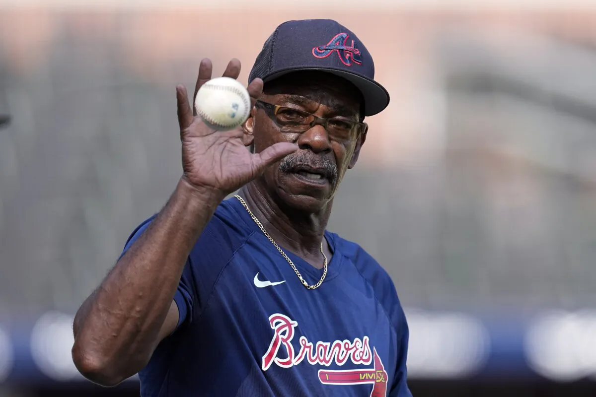 Atlanta Braves third base coach Ron Washington (37) reaches for a ball before a baseball game against the New York Mets in Atlanta on Aug. 21, 2023. (John Bazemore/AP Photo)