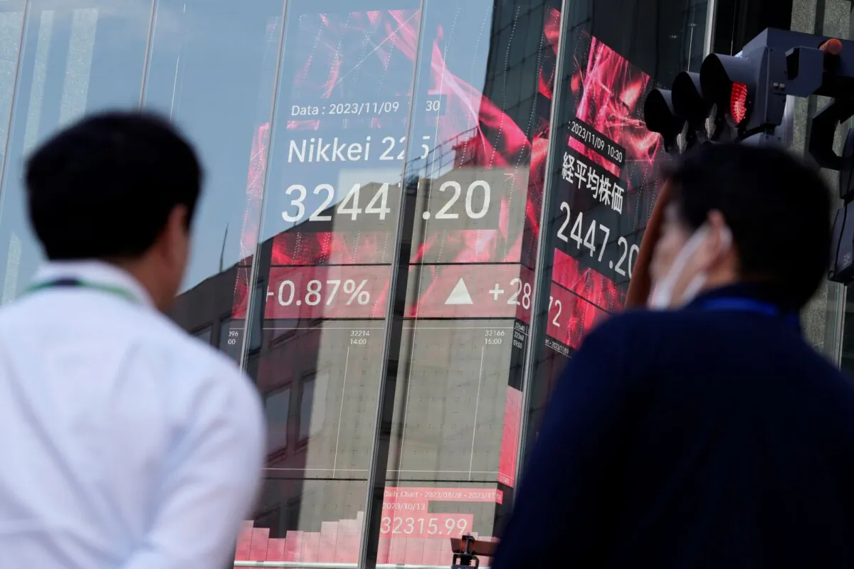 People stand in front of an electronic stock board showing Japan's Nikkei 225 index at a securities firm, in Tokyo on Nov. 9, 2023. (Eugene Hoshiko/AP Photo)