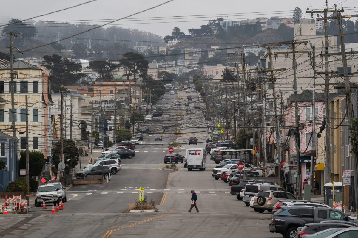 A pedestrian crosses a street in the Outer Sunset district by Ocean Beach in San Francisco on June 26, 2023. (Loren Elliott/Getty Images)