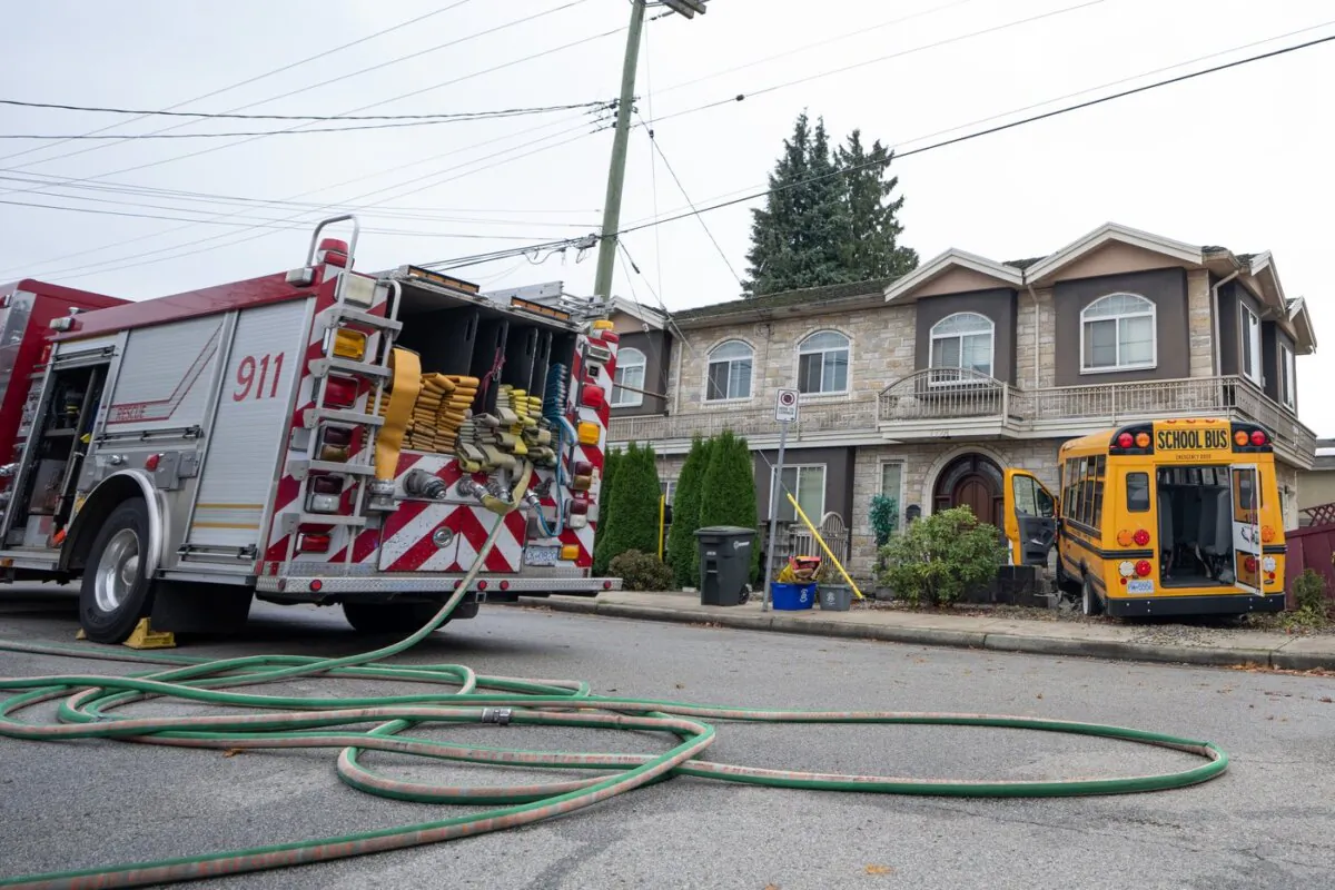A school bus that crashed into a home on 16th Ave in Burnaby B.C. is shown on Nov. 9, 2023. (The Canadian Press/Ethan Cairns)