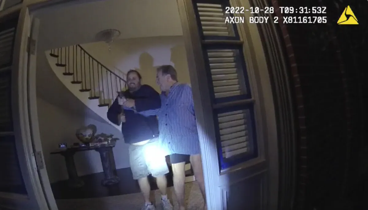 The husband of former U.S. House Speaker Nancy Pelosi, Paul Pelosi (R), fights for control of a hammer with his assailant David DePape during a brutal attack in the couple’s San Francisco home on Oct. 28, 2022, in a still from police body-camera video. (San Francisco Police Department via AP)