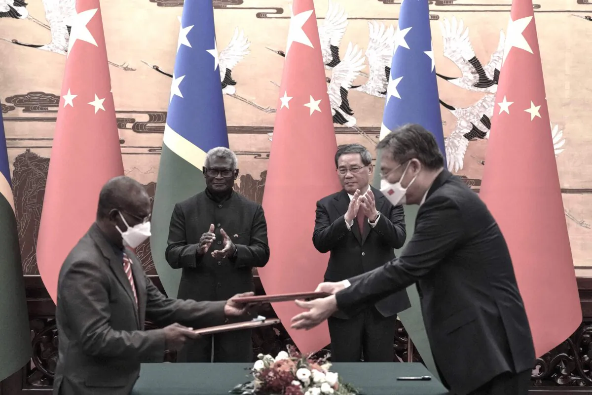 Solomon Islands Prime Minister Manasseh Sogavare (2nd L) and Chinese Premier Li Qiang (2nd R) applaud as the two countries' officials exchange signed documents at the Great Hall of the People in Beijing on July 10, 2023. (Photo by Andy Wong/Pool/AFP via Getty Images)