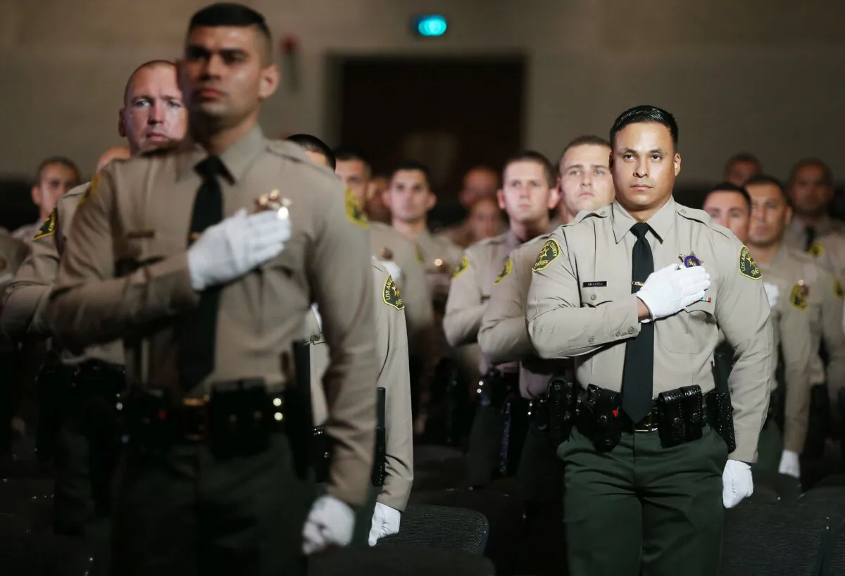 Graduates of Los Angeles County Sheriff's Department Academy stand for the pledge of allegiance at their graduation ceremony at East Los Angeles College in Monterey Park, Calif., on Aug. 21, 2020. (Mario Tama/Getty Images)
