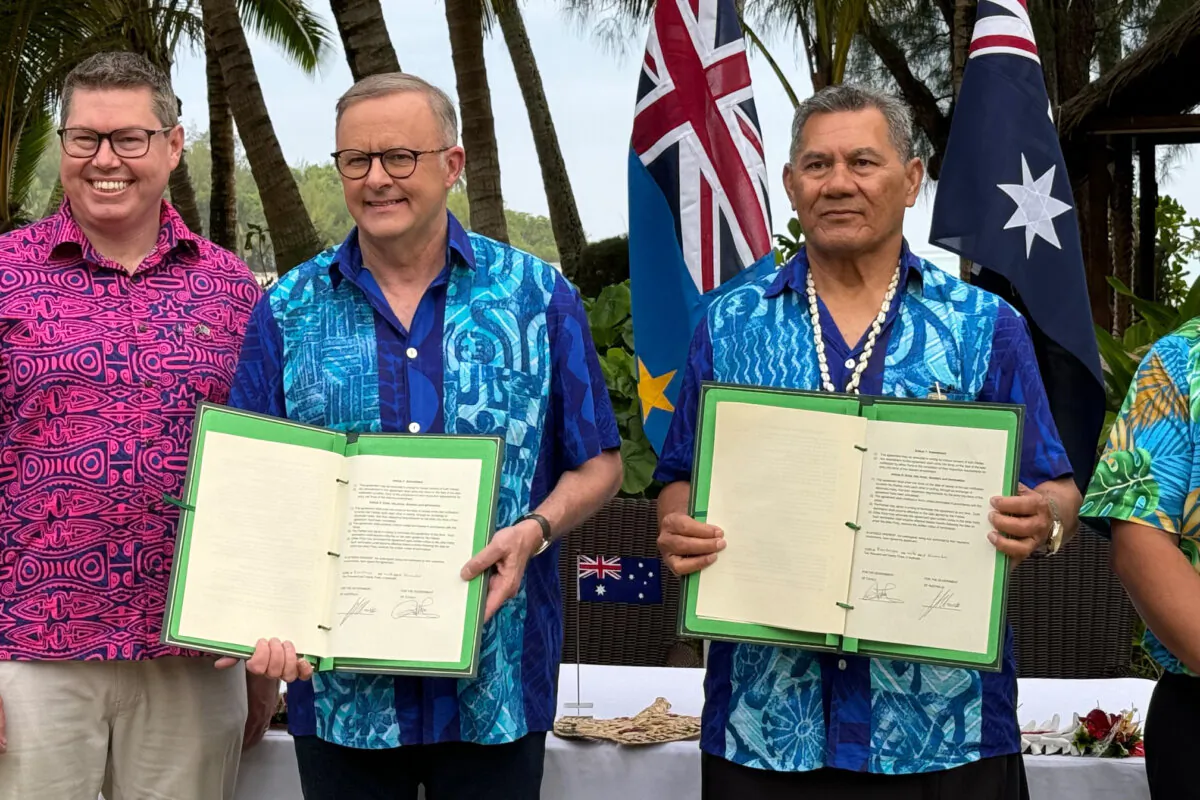 Australian Prime Minister Anthony Albanese and Tuvalu Prime Minister sign a compact between the two nations at the Pacific Resort, Rarotonga, the Cook Islands, Thursday, Nov. 9, 2023. (AAP Image/Ben McKay)