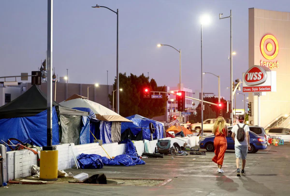 People walk past a homeless encampment near a Target store in Los Angeles on Sept. 28, 2023. A poll found that a quarter of Democrats believe homelessness is the most important issue facing the state. (Mario Tama/Getty Images)