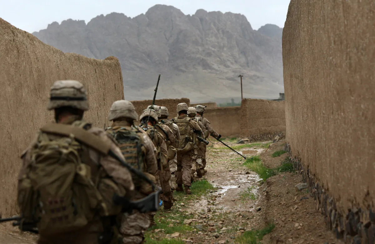 U.S. Marines patrol single file through Now Zad in Helmand province, Afghanistan, on April 1, 2009. Taliban have buried IEDs throughout the abandoned city, and U.S. forces there patrol through unpaved areas behind a mine sweeper in "Ranger file" to avoid stepping on the hidden explosives. (John Moore/Getty Images)