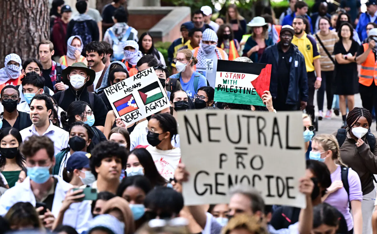 A protester holds a placard showing a Palestinian flag alongside a flag of Artsakh (the Armenian name for Nagorno-Karabakh) as students participate in a "Walkout to fight Genocide and Free Palestine" at Bruin Plaza at UCLA, in Los Angeles on Oct. 25, 2023. (Frederic J. Brown/AFP/Getty Images)