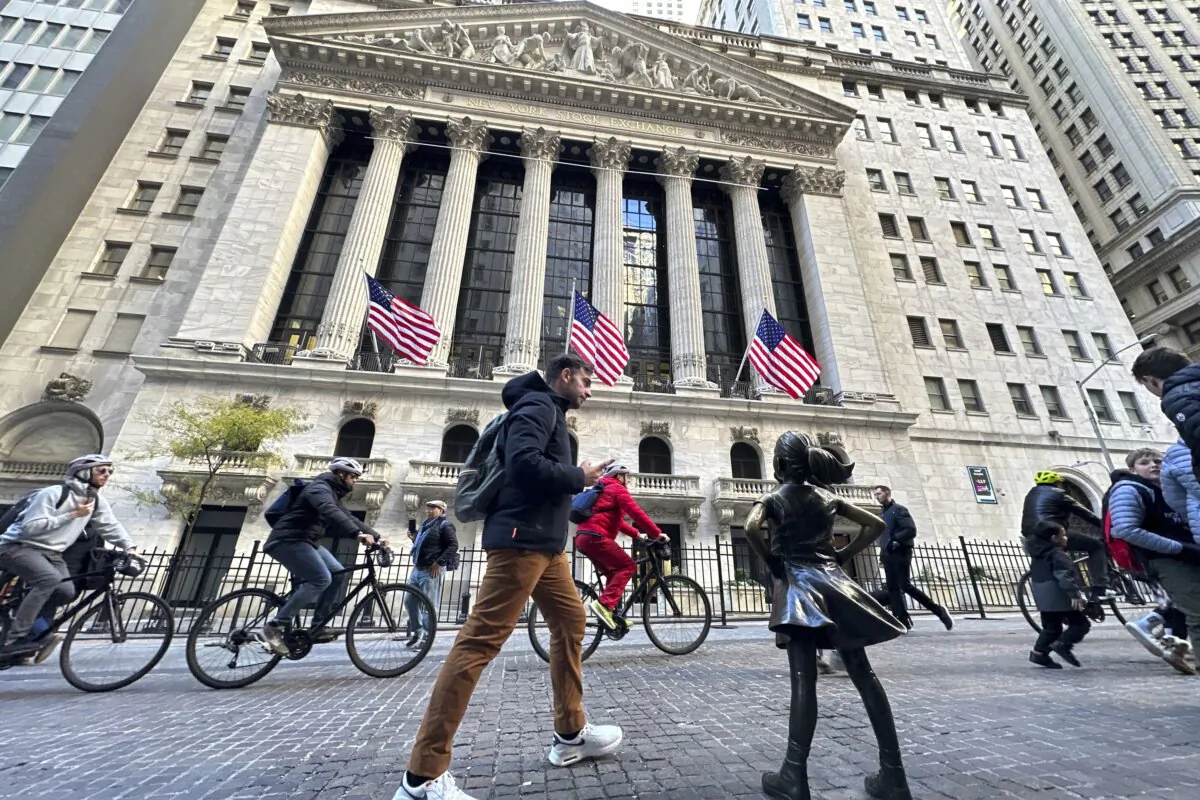 A man passes the "Fearless Girl" statue in front of the New York Stock Exchange in New York on Nov. 3, 2023. (Ted Shaffrey/AP Photo)