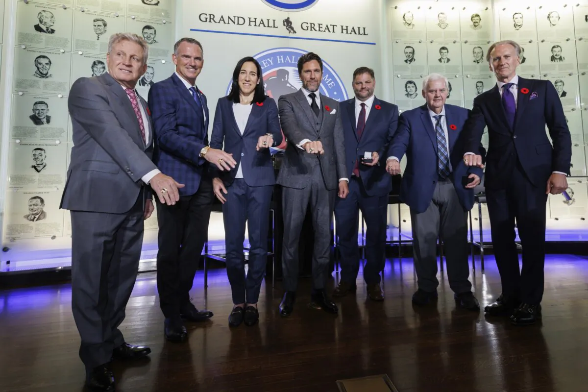 Hockey Hall of Fame 2023 inductees show of their rings during ceremonies in Toronto on Nov. 10, 2023. From left are Mike Vernon, Pierre Turgeon, Caroline Ouellette, Henrik Lundqvist, Eric Lacroix (son of inductee Pierre Lacroix), Ken Hitchcock, and Tom Barrasso. (Cole Burston/The Canadian Press via AP)
