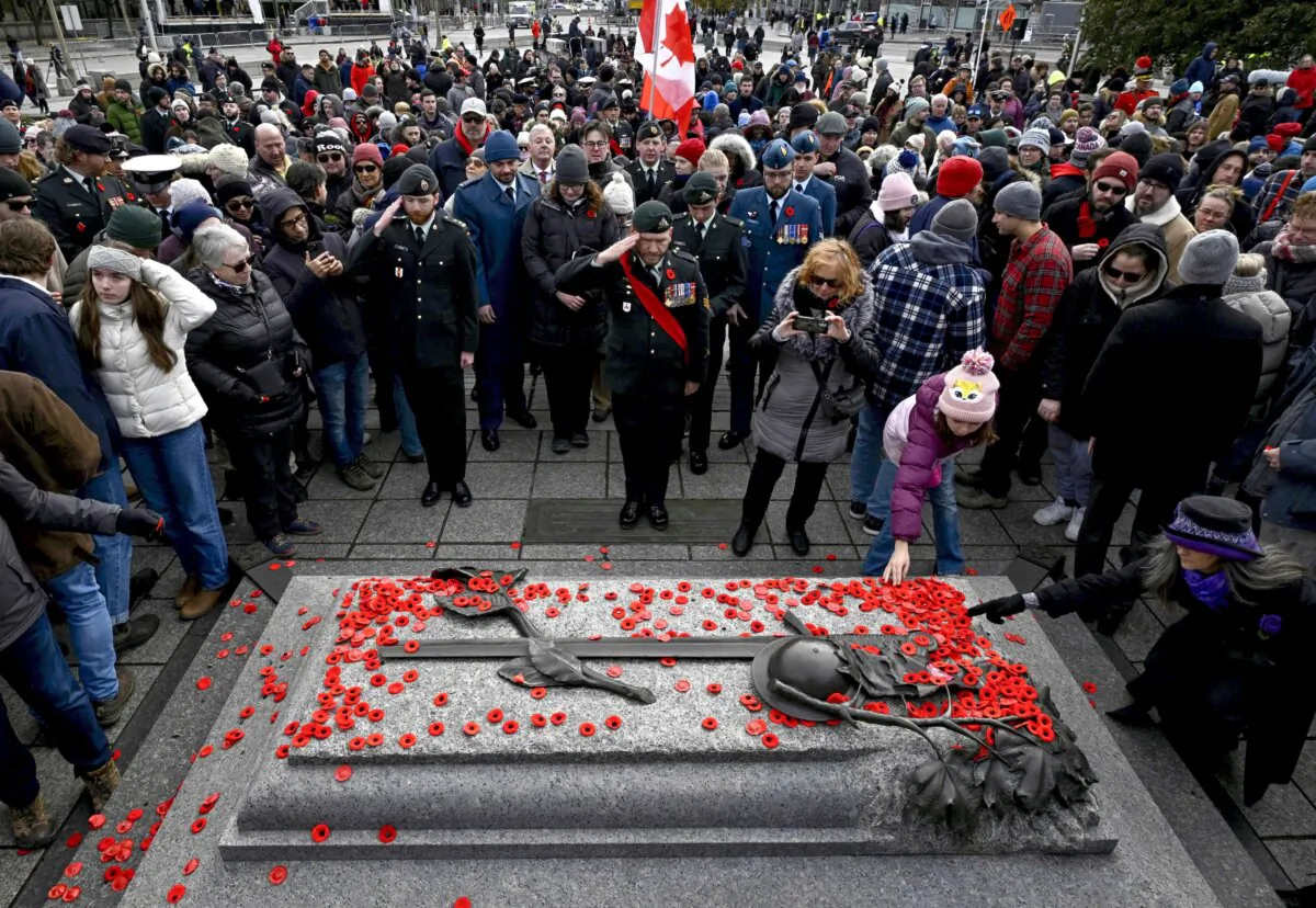 Canadian Armed Forces members salute as poppies sit on the Tomb of the Unknown soldier after the Remembrance Day Ceremony at the National War Memorial in Ottawa on Nov. 11, 2023. (The Canadian Press/Justin Tang)