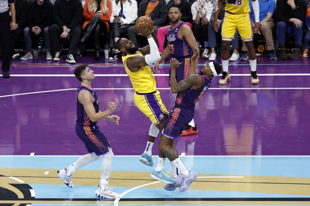 LeBron James (23) of the Los Angeles Lakers attempts a shot over Bradley Beal (3) of the Phoenix Suns and Grayson Allen (8) during the second half of the NBA In-Season Tournament game in Phoenix on Nov. 10, 2023. (Chris Coduto/Getty Images)