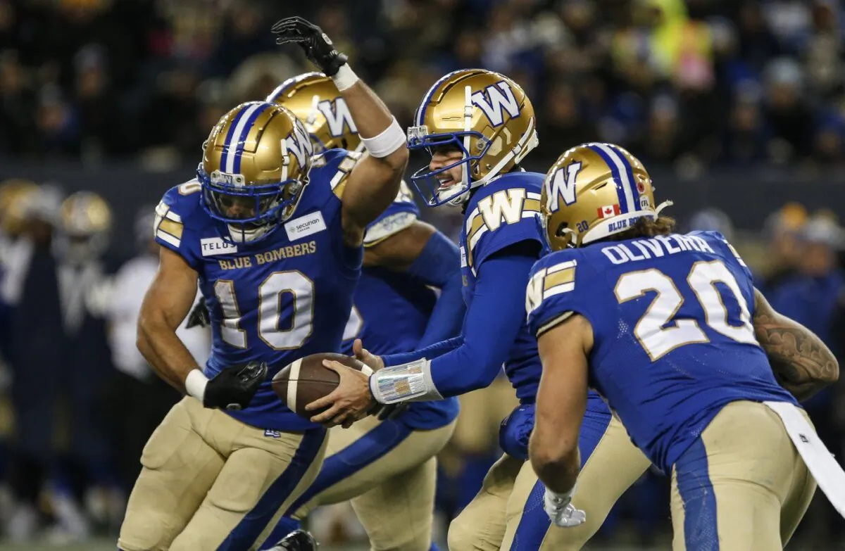 Winnipeg Blue Bombers quarterback Zach Collaros (8) fakes the handoff to Nic Demski (10) and gives it to Brady Oliveira (20) during first half CFL action against the B.C. Lions in Winnipeg Nov. 11, 2023. (The Canadian Press/John Woods)