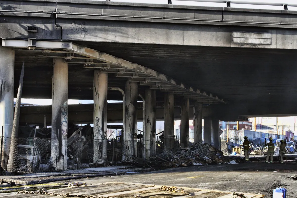Los Angeles firefighters mop up from a fire under Interstate 10 that severely damaged the freeway in an industrial zone near downtown Los Angeles on Nov. 11, 2023. (Richard Vogel/AP Photo)