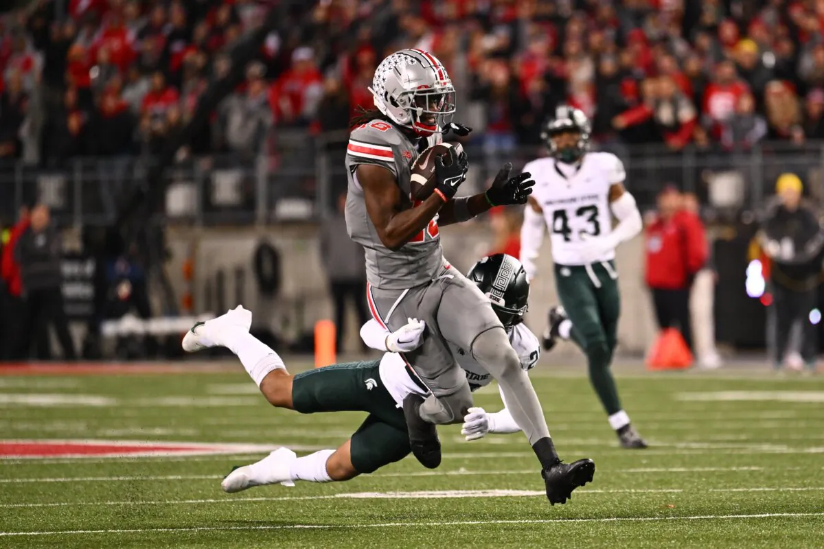 Marvin Harrison Jr. (18) of the Ohio State Buckeyes breaks away from a tackle by Ade Willie (20) of the Michigan State Spartans during the third quarter of a game in Columbus, Ohio on Nov. 11, 2023. (Ben Jackson/Getty Images)