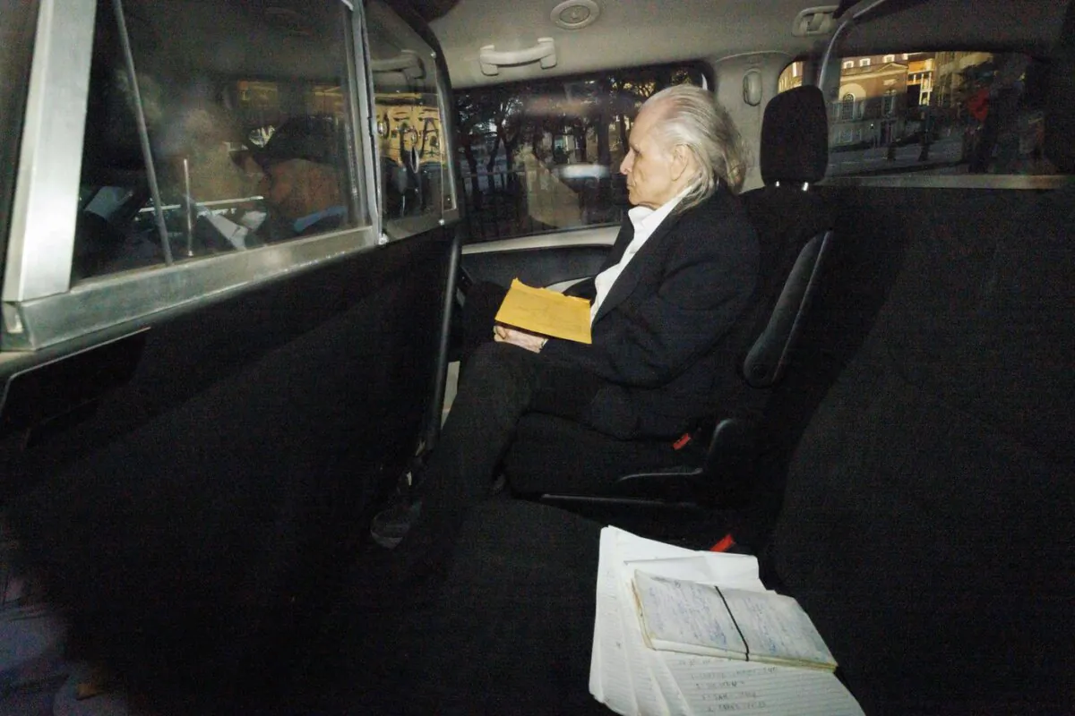 Seen through a police vehicle window, Peter Nygard arrives to a Courthouse in Toronto, on Oct. 3, 2023. (The Canadian Press/Cole Burston)