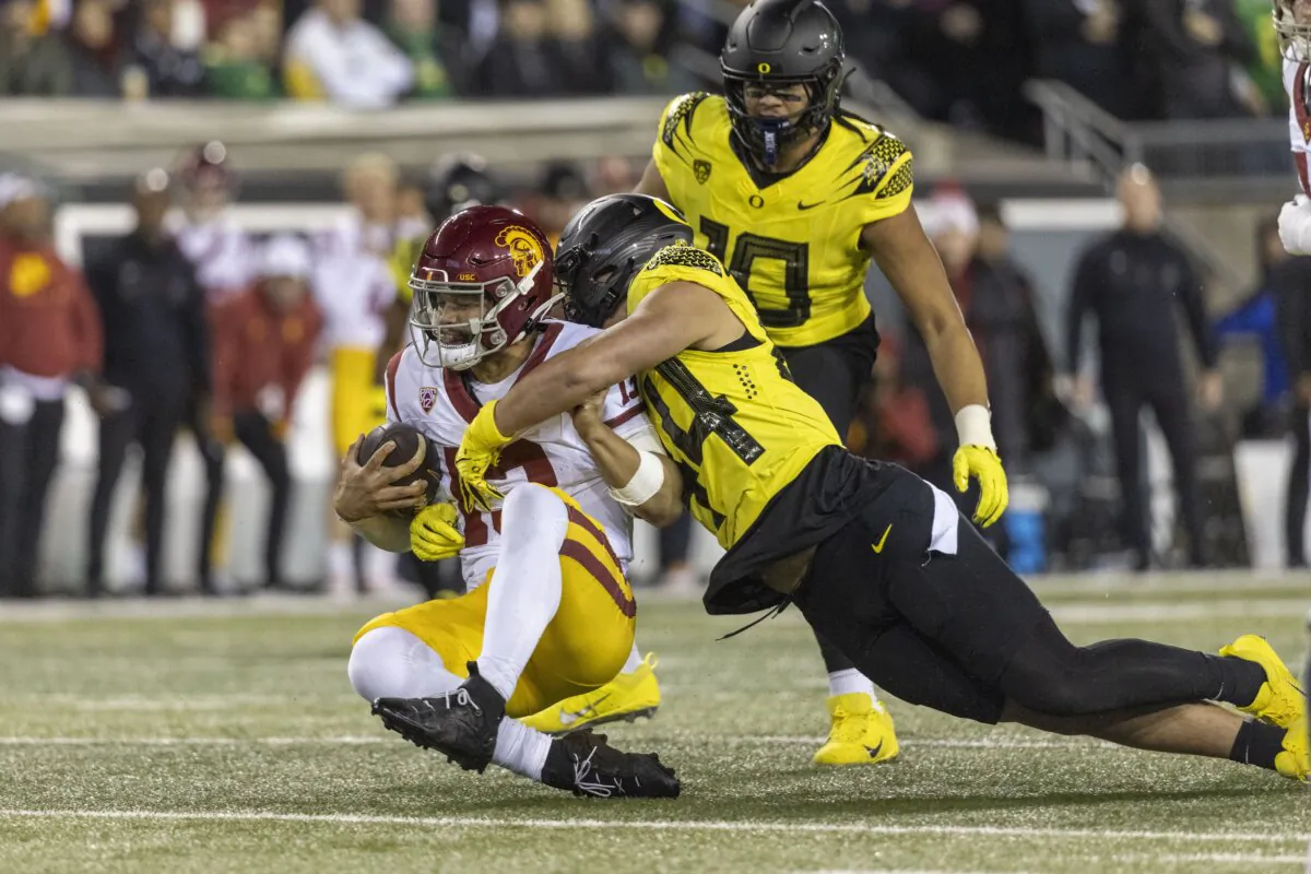Quarterback Caleb Williams (13) of the USC Trojans is sacked by linebacker Teitum Tuioti (44) of the Oregon Ducks in Eugene, Ore., on Nov. 11, 2023. (Tom Hauck/Getty Images)