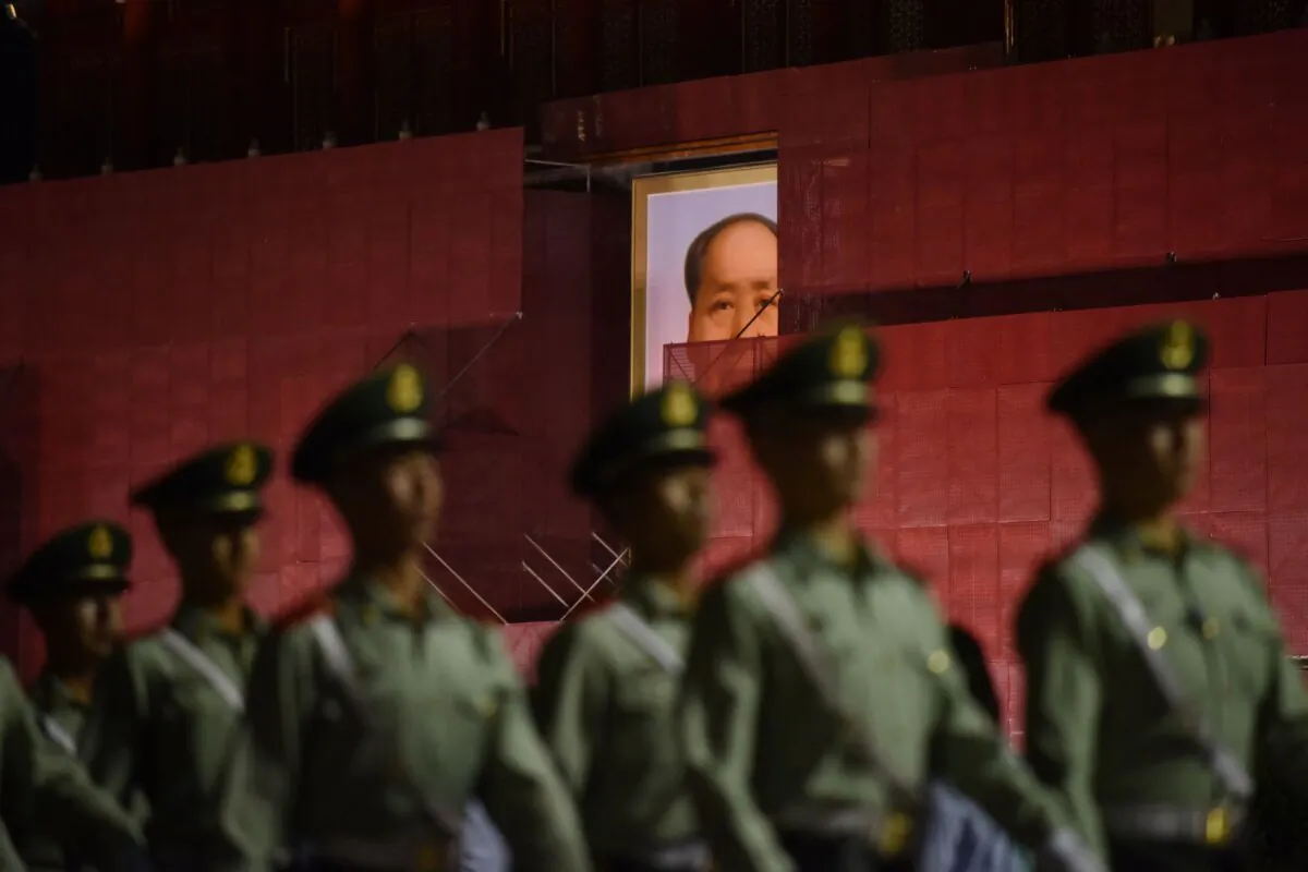 Paramilitary police officers march past the portrait of late communist leader Mao Zedong on Tiananmen Gate as it undergoes renovations in Beijing on May 18, 2019. (GREG BAKER/AFP via Getty Images)